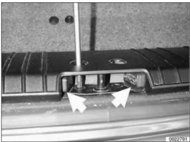 Close-up of a mechanical component with two white arrows pointing to a specific part (no visible text or symbols)