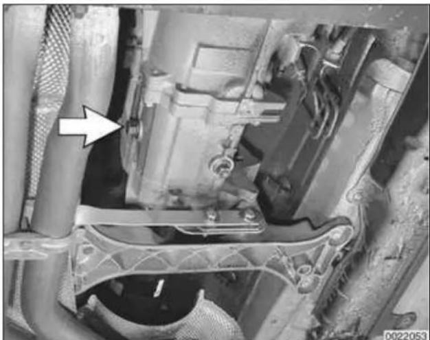 Close-up of a mechanical assembly with visible components and a white arrow pointing to a component (no text or symbols)
