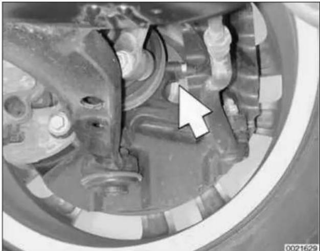 Close-up of mechanical components with a white arrow pointing to a specific part (no visible text or symbols)