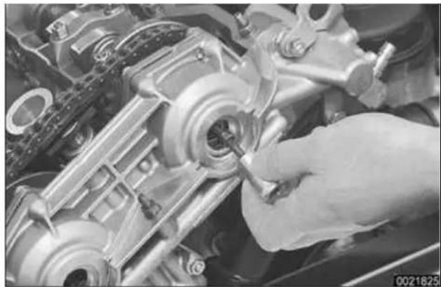 Close-up of a hand using a tool to adjust or install a mechanical component (no visible text or symbols)
