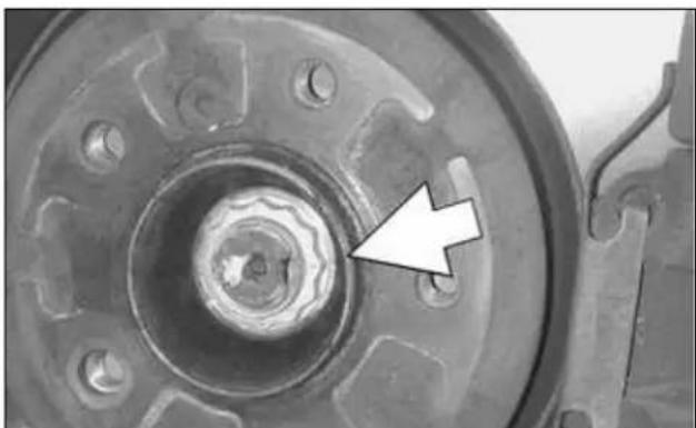 Close-up of a mechanical component with a central hub and a white arrow pointing to a detail (no text or symbols visible)