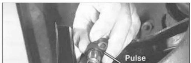 Close-up of a hand using a tool to adjust or install a component labeled 'Pulse' (no other text or symbols visible)