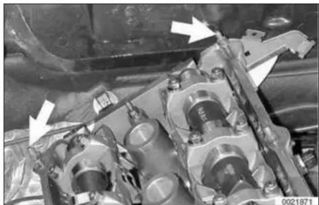 Close-up of an engine cylinder assembly with visible mechanical components and directional arrows (no text or symbols)