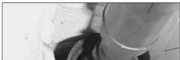 Close-up of a mechanical component with textured surface and circular opening (no visible text or symbols)