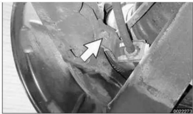 Close-up of a mechanical component with a white arrow pointing to a specific area (no visible text or symbols)