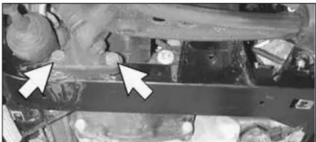 Close-up of a mechanical component with two white arrows pointing to features, no visible text or symbols.