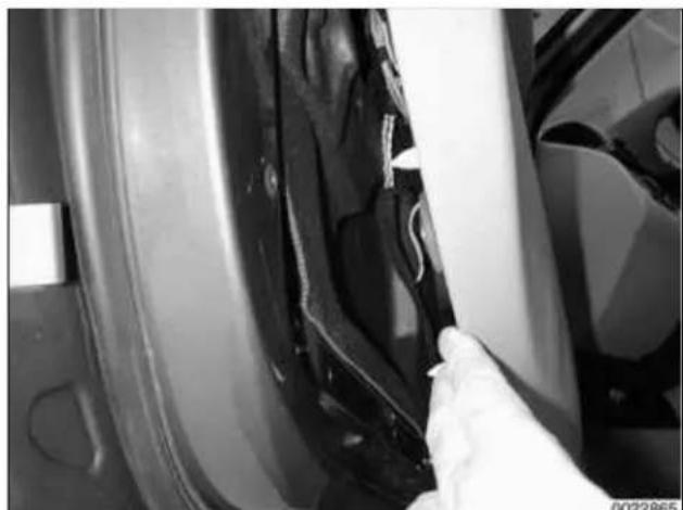 Close-up of a hand cleaning a car's side panel with visible paint and components (no text or symbols)