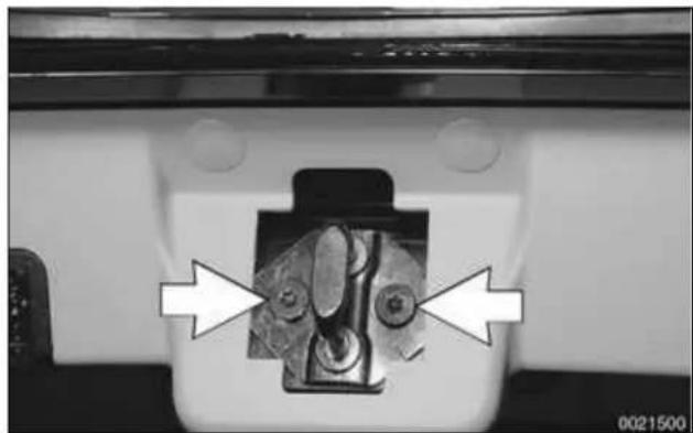 Close-up of a mechanical component with two white arrows pointing to features, no visible text or symbols.