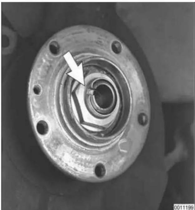 Close-up of a mechanical component with a white arrow pointing to a circular feature, no visible text or symbols.