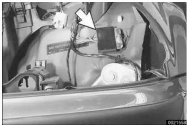 Interior view of a car with visible electrical equipment and a white arrow pointing to a device (no text or symbols)
