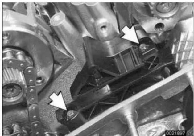 Close-up of mechanical components with white arrows pointing to specific parts (no visible text or symbols)