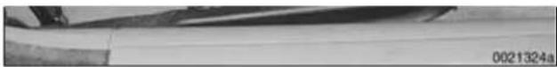 Close-up of a wooden surface with visible grain and a small object, no text or symbols present.