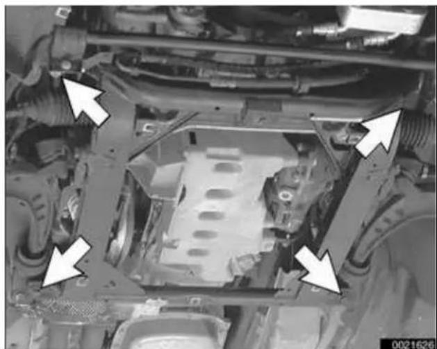 Close-up of an automotive chassis frame with white arrows pointing to structural components (no visible text or symbols)