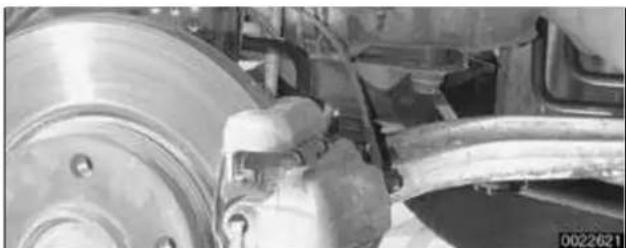 Close-up of a car brake system with a hand operating the wheel (no visible text or symbols)