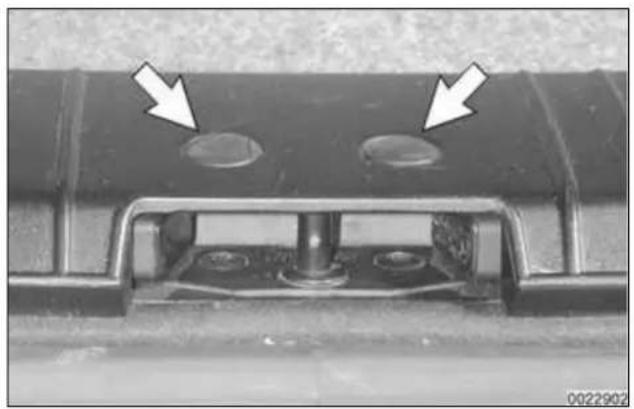 Close-up of a mechanical component with two circular holes and a central shaft, showing mounting brackets and a base (no text or symbols visible)