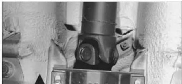 Close-up of a mechanical component with bolts and a metallic shaft (no visible text or symbols)