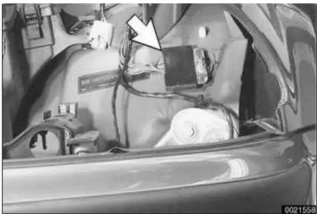 Interior view of a car with visible electrical equipment and a white arrow pointing to a device (no text or symbols)