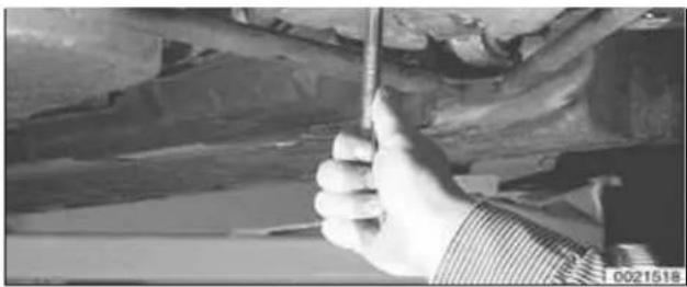 Close-up of a hand using a tool to adjust or install vehicle components (no visible text or symbols)