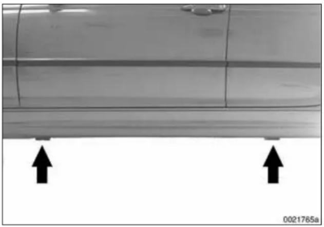Close-up of a car's side panel with two upward arrows indicating measurement or alignment points (no text or symbols present)