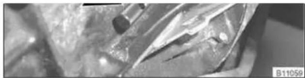 Close-up of a textured surface with dark circular features and a small dark spot, possibly biological or material sample (no visible text or symbols)