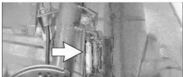 Close-up of mechanical components with an arrow pointing to a component (no visible text or symbols)