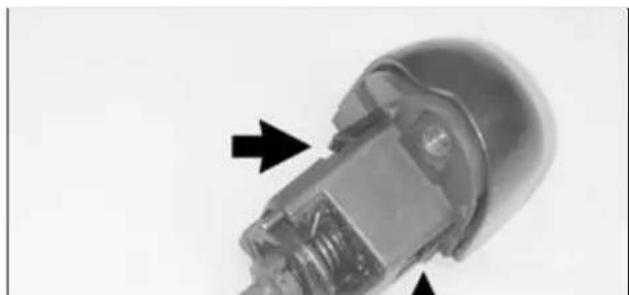 Close-up of a mechanical component with arrows pointing to internal features (no visible text or symbols)