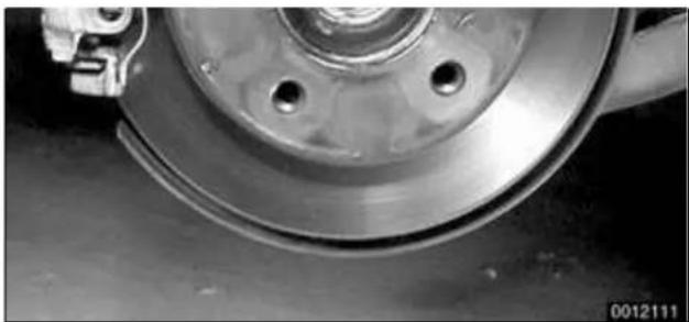 Close-up of a car brake caliper and wheel assembly (no visible text or symbols)