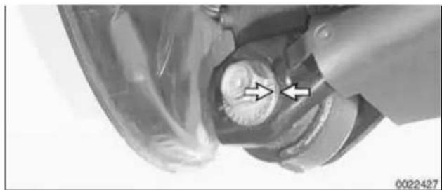 Close-up of a mechanical component with two arrows pointing to a circular feature (no visible text or symbols)
