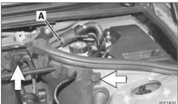 Close-up of a car engine bay with visible hoses and components, no text or symbols present