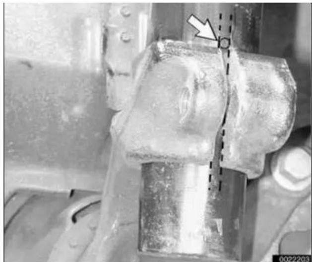 Close-up of a metallic mechanical joint with a dashed line and arrow indicating a measurement or inspection point (no text or symbols present)