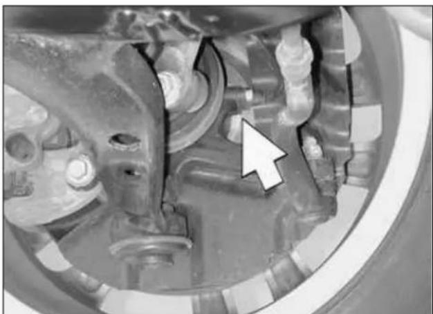 Close-up of mechanical components with a white arrow pointing to a specific part (no visible text or symbols)