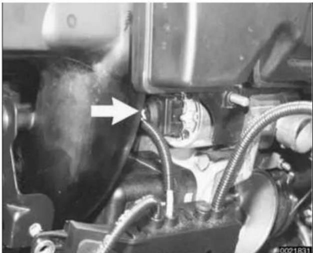 Close-up of a car engine component with hoses and exhaust pipe (no visible text or symbols)