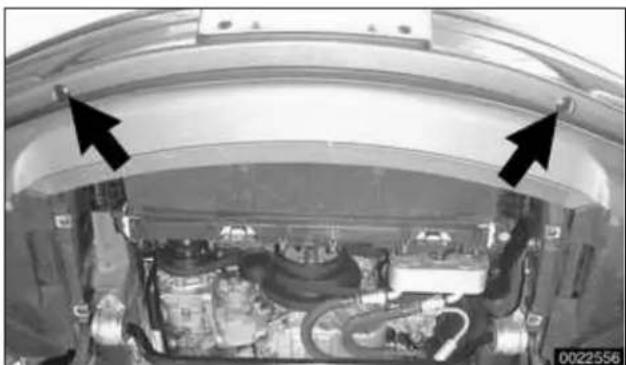 Interior view of a vehicle engine bay with visible structural components and two black arrows pointing to specific parts (no text or symbols)
