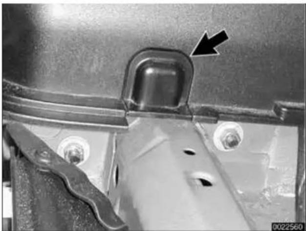 Close-up of a metallic mechanical component with a black arrow pointing to a square feature (no text or symbols visible)