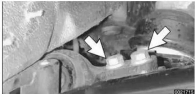 Close-up of mechanical components with two white arrows pointing to specific areas (no visible text or symbols)