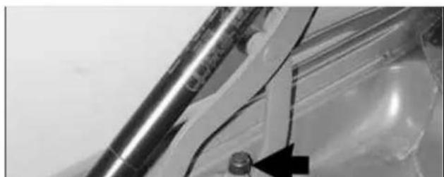 Close-up of a metallic tool with a black arrow pointing to a small component (no visible text or symbols)