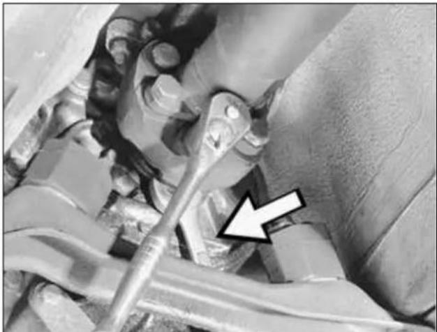 Close-up of mechanical components with a white arrow pointing to a specific part (no visible text or symbols)