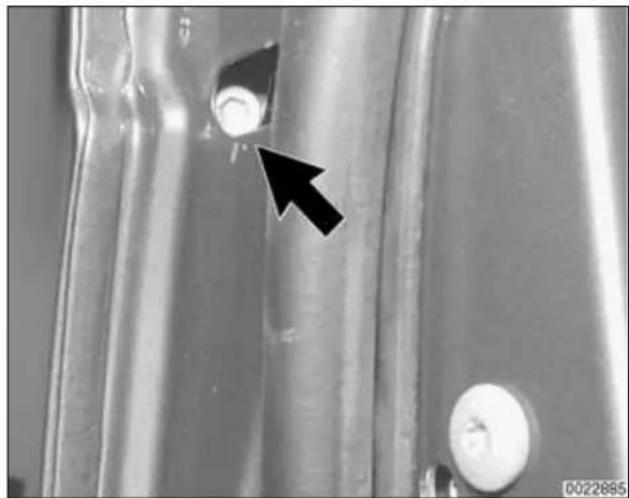 Close-up of metallic cylindrical components with a black arrow pointing to a small circular feature (no text or symbols visible)