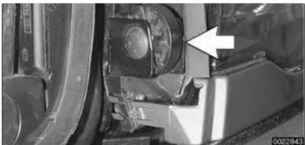 Close-up of a mechanical component with an arrow pointing to a circular feature, no visible text or symbols.