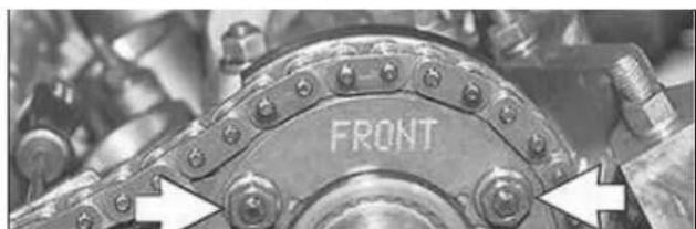 Close-up of a mechanical component with bolt holes and a 'FRONT' label, no readable text beyond the label