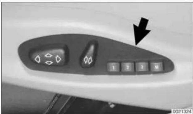 Close-up of a car air conditioner control panel with buttons and a black arrow pointing to the button (no text or symbols visible)