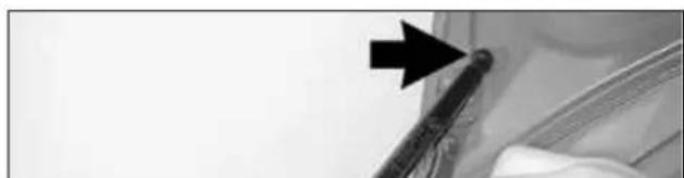 Close-up of a mechanical component with a black arrow pointing to a detail (no visible text or symbols)