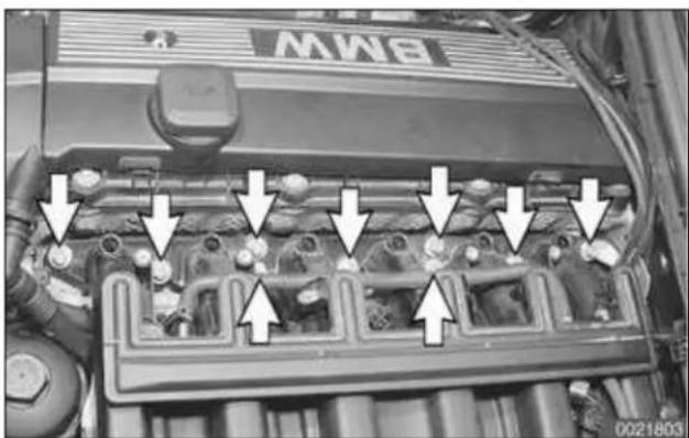 Engine bay with multiple engine components and white arrows indicating directional flow or movement (no text or symbols)