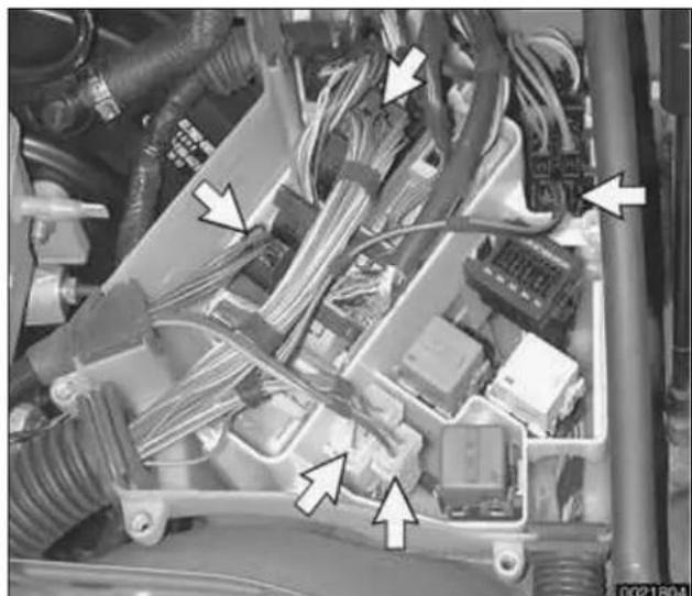 Interior view of an automotive engine bay with visible wiring and components (no text or symbols)