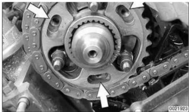 Close-up of a mechanical gear assembly with mounting holes and chain links (no visible text or symbols)