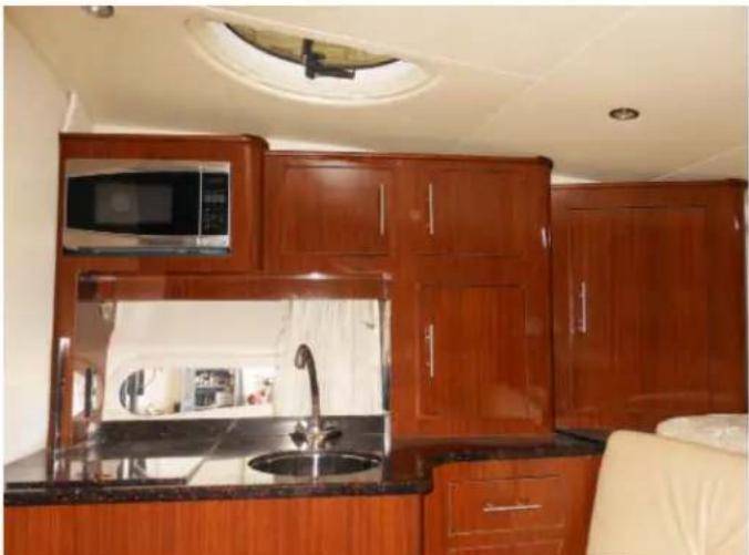 Interior view of a modern kitchen with wooden cabinets, microwave, and a sink (no visible text or symbols)