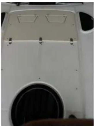 Close-up of a white car front panel with a black circular vent and two rectangular vented areas (no text or symbols visible)