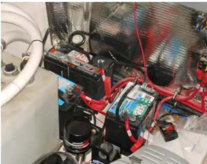 Interior view of an industrial vehicle showing battery, red cables, and wiring (no visible text or symbols)