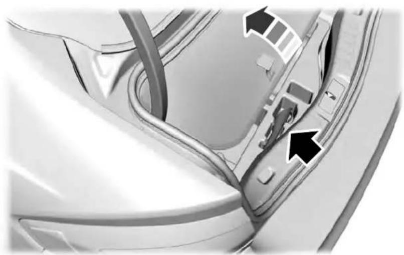 Close-up of a car interior showing a handle, seatbelt, and door panel with two black arrows pointing to the side (no text or symbols visible)