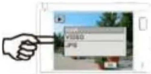 Hand holding a document with visible text 'VSSS' and 'JPG' on the page, displayed in an outdoor setting.